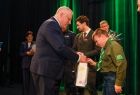 Wicemarszałek Ryszard Pagacz wręcza prezent harcerzowi.
