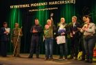 Ludzie stoją na scenie i rozmawiają.