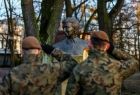 Żołnierze salutują przed pomnikiem.