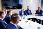 Przedstawiciele gmin siedzą przy stole.