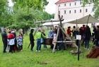 Ludzie stoją w trawie.