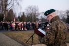 Żołnierz stoi przy mikrofonie.