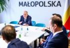 Wicemarszałek Ryszard Pagacz siedzi przy stole. Za nim widoczny napis Małopolska.