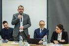 Mężczyzna stoi i trzyma w ręce mikrofon.