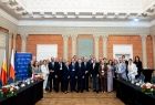 Zdjęcie grupowe na tle flag Małopolski, Polski i Unii Europejskiej.