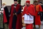 Dwóch mężczyzn w strojach historycznych. Za nim inni ludzie idą.
