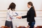 Uczennica odbierająca list gratulacyjny.