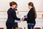 Uczennica i nauczycielka odbierające listy gratulacyjne.