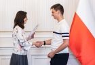 Uczeń w białej koszulce polo odbierający gratulacje.
