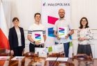 Uczeń w białej koszulce polo i nauczyciel z dwiema przedstawicielkami UMWM.