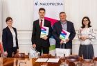 Uczeń w garniturze i nauczyciel z dwiema przedstawicielkami UMWM.