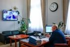 Wicemarszałek Ryszard Pagacz siedzi przy biurku. Na ścianie widoczny ekran i zegar.