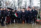 Ludzie stoją pod parasolami.