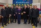 uczestnicy wydarzenia stoją w remizie. Z tyłu widoczny napis Małopolska.