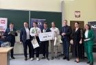 Studenci stojący na środku sali wykładowej, odbierający nagrody i wyróżnienia