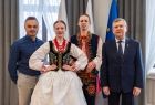 Wicemarszałek Witold Kozłowski stoi z zespołem ludowym.