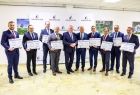 Wicemarszałek Ryszard Pagacz stoi z beneficjentami.