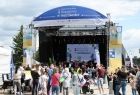 Ludzie stoją przed sceną.