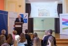 Wicemarszałek Ryszard Pagacz stoi przy mównicy. Przed nim siedzą ludzie.