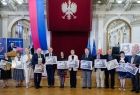 Wicemarszałek Ryszard Pagacz stoi z innymi ludźmi na sali.