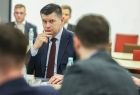Marszałek Łukasz Smółka siedzi przy stole.
