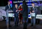Wicemarszałek Witold Kozłowski przekazujący dokument kobiecie.