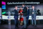 Wicemarszałek Witold Kozłowski przekazujący dokument mężczyźnie.