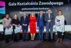 Wicemarszałek Witold Kozłowski z nagrodzonymi nauczycielami na scenie.