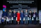 Wicemarszałek Witold Kozłowski z laureatami i nauczycielami na scenie.