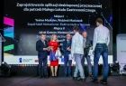 Dwaj uczniowie podchodzący na scenie do wicemarszałka Witolda Kozłowskiego.