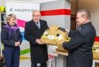 Wicemarszałek Ryszard Pagacz podaje mundur strażakowi.