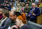 Wicemarszałek Ryszard Pagacz siedzi na widowni z broszurą.