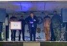 Dyrektor stoi przy mikrofonie i czyta list.