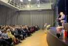 Wicemarszałek Ryszard Pagacz stoi na scenie. Przed nim siedzi widownia.