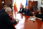 Wicemarszałek Witold Kozłowski siedzi przy stole z gośćmi.