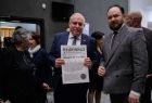 Wicemarszałek Ryszard Pagacz trzyma w rękach gazetę. Obok stoi mężczyzna.