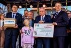 Wicemarszałek Ryszard Pagacz stoi z dziewczynką na scenie.