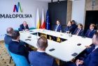 Wicemarszałek Ryszard Pagacz stoi z beneficjentami na sali.