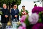 Wicemarszałek Ryszard Pagacz stoi na cmentarzu z innymi ludżmi.