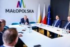 Wicemarszałek Ryszard Pagacz siedzi z beneficjentami.