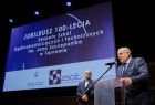 Wicemarszałek Ryszard Pagacz stoi na scenie przy mównicy.