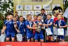 Grupa zawodników w niebieskich strojach przed wejściem na podium.
