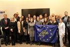 Ludzie stoją i trzymają flagę Unii Europejskiej z napisem Life.