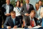 Dwóch mężczyzn podpisuje umowę.