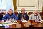 Trzech mężczyzn siedzi przy stole.