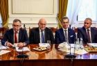 Czterech mężczyzn siedzi przy stole.