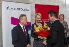 Ks. Łukasz Piórkowski, dyrektor Muzeum Dom Rodzinny Ojca Świętego Jana Pawła II w Wadowicach, wręcza Iwonie Gibas z zarządu województwa bukiet kwiatów. Obok stoją radny Rafał Stuglik i Monika Gubała, dyrektor departamentu kultury urzędu marszałkowskiego