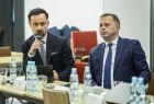 Dwóch mężczyzn siedzi przy stole.