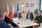 Wicemarszałek Ryszard Pagacz siedzi przy stole z mężczyznami.