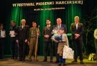 Ludzie stoją na scenie.